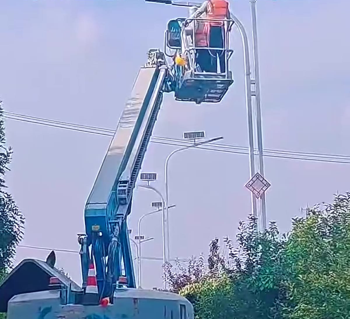 Técnicos trabajando en la cabeza de una farola solar durante la instalación